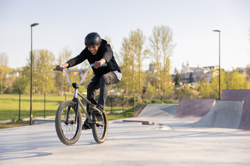 A young boy mastered riding a low trick bike,bmx, I try to lift the front wheel, he is fascinated,...