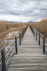 Vertical view of a wooden bridge leading through marshes and lakes inside the Central Anatolian Sultan Reedy (Sultansazligi) National Park, Turkey