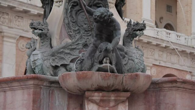 LORETO, ITALY. Close up the old fountain in Madonna Square, next to Apostolic Palace is one of the most beautiful landmarks, decorated with heraldic dragons, tritons and dolphins