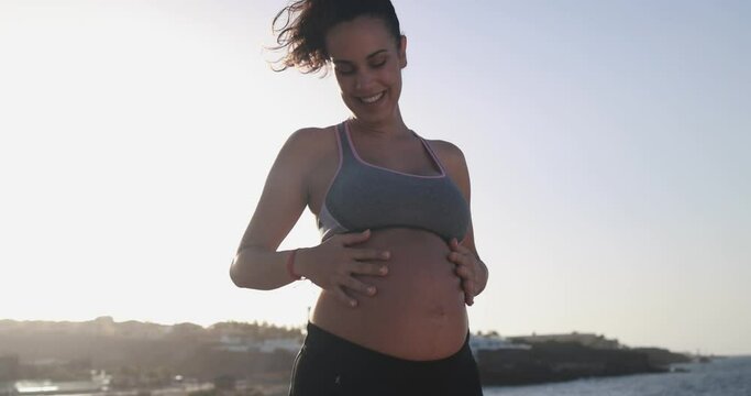 Young pregnant woman doing yoga outdoor - Sport exercises and maternity concept for an healthy lifestyle