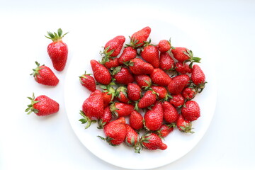 Top view of strawberries on white plate and background 