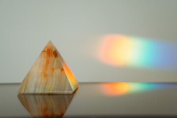 Agate pyramid with a rainbow streak background