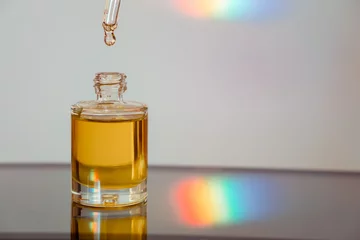 Foto op Plexiglas Face oil on reflective surface with a rainbow streak © NadiaA