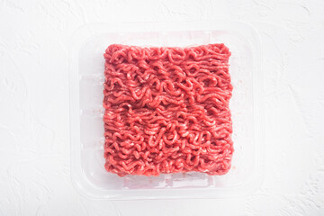 Raw Minced Meat in a transparent Plastic Container, on white stone  background, top view flat lay, with copy space for text