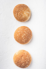 Sandwich bun with sesame seeds, on white stone  background, top view flat lay