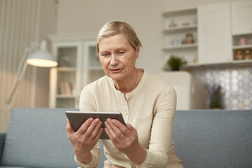 Senior woman using digital tablet at home. The use of technology by the elderly.