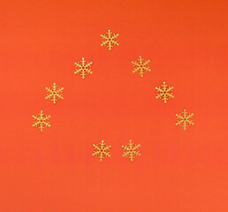 Fototapeta na wymiar Christmas, winter composition. Xmas decorations, golden snowflakes on red orange