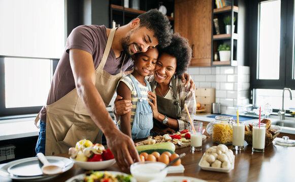 Happy family preparing healthy food in kitchen together