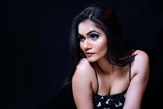 Young Indian fashion model on black background. Looking at camera. Copy space