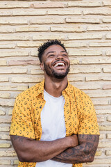 Portrait of a handsome black man smiling with a brick background