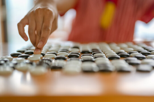 close up of young women hand make a move in Go game(Weiqi,Baduk),Traditional  strategy board game