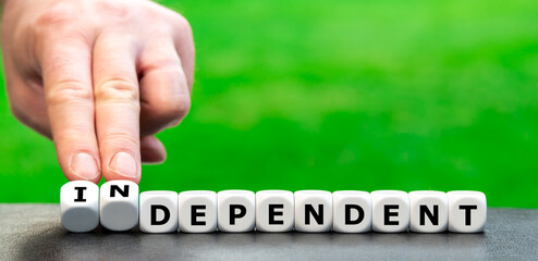 Hand turns dice and changes the word "dependent" to "independent".