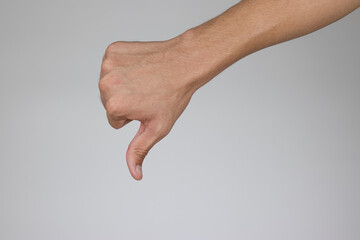 The hand of a man who is raising his thumbs down expresses his dislike of rejection.( Clipping Path )