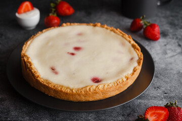 Delicious pie with strawberries and cream. Pie on the table. Pie with berries on a plate 
