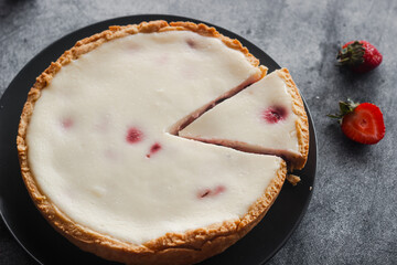 Delicious pie with strawberries and cream. Pie on the table. Pie with berries on a plate 
