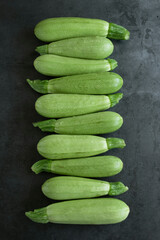 Food background - raw fresh zucchini on grey background
