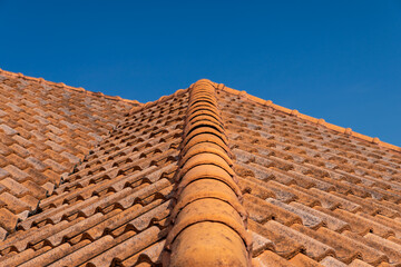 Close up of brown clay roof tiles. Red old dirty roof. Old roof tiles. Construction equipment build a house.