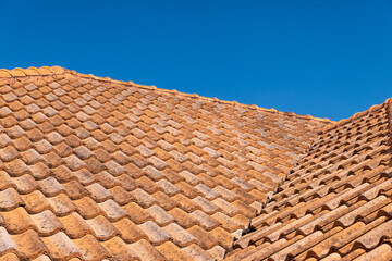 Close up of brown clay roof tiles. Red old dirty roof. Old roof tiles. Construction equipment build a house.