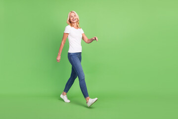 Full length body size photo senior woman walking on meeting laughing isolated on pastel green color background copyspace