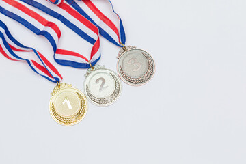Gold, silver and bronze sports achievement medals for first, second and third place, on a white...