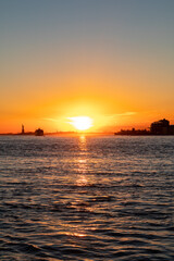 Fototapeta premium Beautiful New York City Sunset along the East River and Hudson River with the Statue of Liberty
