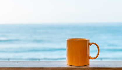 モーニングコーヒーのイメージ　マグカップと青い海と波　