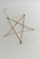 isolated bamboo skewer 5 pointed arts and crafts star tied with twine on paper