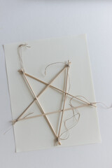 isolated bamboo skewer 5 pointed arts and crafts star tied with twine on paper