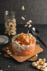 Garnishing a cup of carrot halwa with cashew pieces