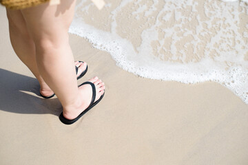 Fototapeta na wymiar women feet are stand on the sandy beach