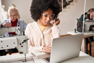 Woman sitting in front of the laptop and chatting with colleagues remotely