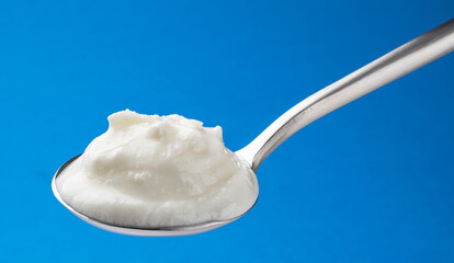 Fototapeta na wymiar Fresh curdled milk, homemade sour yogurt in spoon
