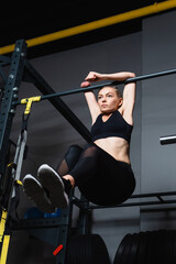 Fototapeta na wymiar low angle view of disabled woman exercising on horizontal bar