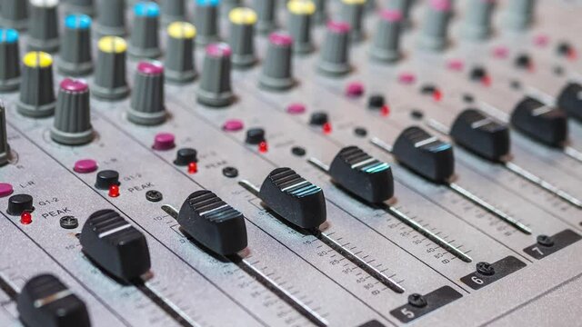 Moving sliders on audio mixer in a recording studio. Time lapse. Chaotic movement of mixconsole faders on digital audio channels. Adjusting sound volume on console control panel. Zoom. Motion Lapse.