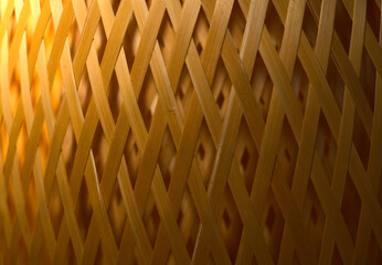 The texture is made of woven wooden mesh lined with diamonds. With an overflow of light from light to dark and rounded. Closeup