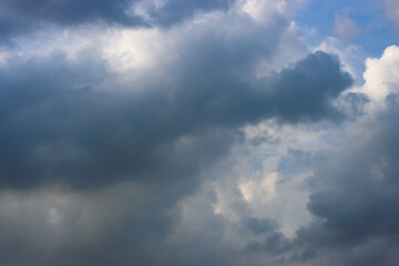 Dark blue cloud moving under the blue sunny sky
