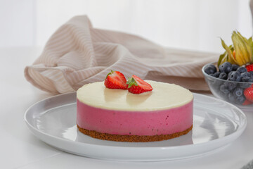 Decoration of vegetarian dessert, cake with berries. Ingredients: almond sponge biscuit, raspberry mousse, white chocolate ganache. The concept of vegan treats.