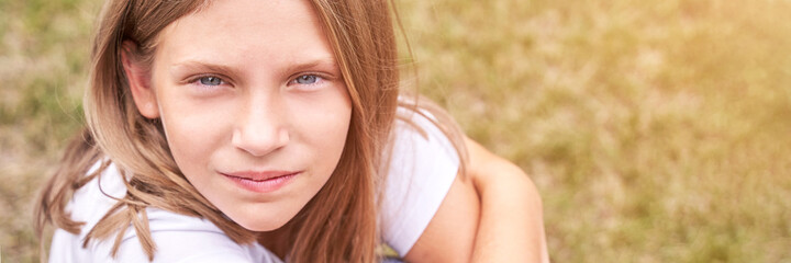 Little girl portrait. Outdoor green background. Looking. Teenager schoolgirl at park. Cute face. Children beauty. Female head. Charisma caucasian