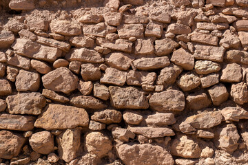 Masonry texture from large rough red stones. Weathered stone wall for background