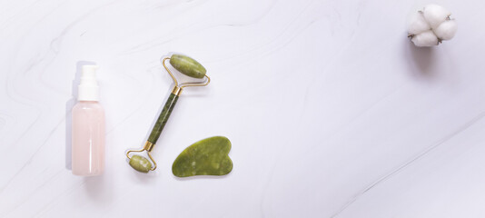 Jade Guasha Scraper cupping roller facial massager and cosmetic cream. The concept of self-care. Zero waste. Lifting and toning treatment at home.