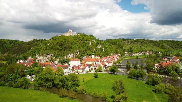 Drone circling around the town of Kallm&uuml;nz in Bavaria on sunny day with dramatic clouds