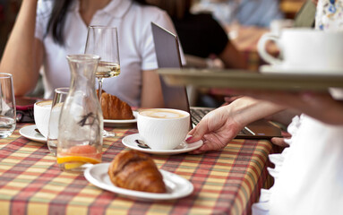waitress holding tray with cups of coffee