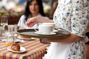 waitress holding tray with cups of coffee