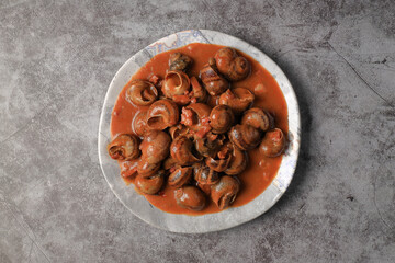 Serving of stewed snails in sauce