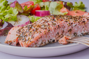 Baked salmon fillet with salad.