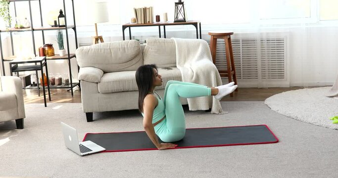 Home training. Sporty black woman exercising at laptop. Online Training.