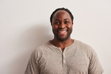 Multiracial man with dreadlocks in domestic clothes looking at the camera