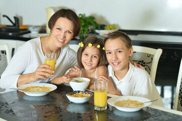 Cute family  eating  together in kitchen