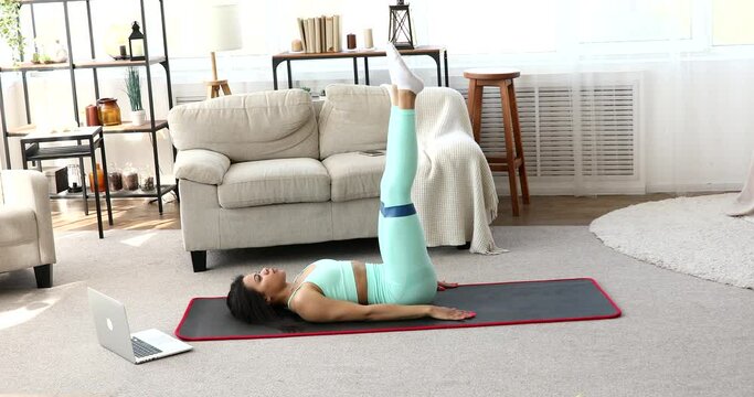 Home training. Sporty black woman exercising at laptop. Online Training.