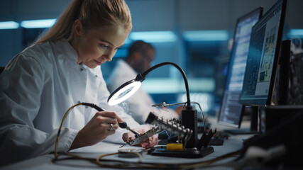 Modern Electronics Research and Development Facility: Beautiful Caucasian Female Engineer Does Computer Motherboard Soldering. Scientists Design Industrial PCB, Silicon Microchips, Semiconductors